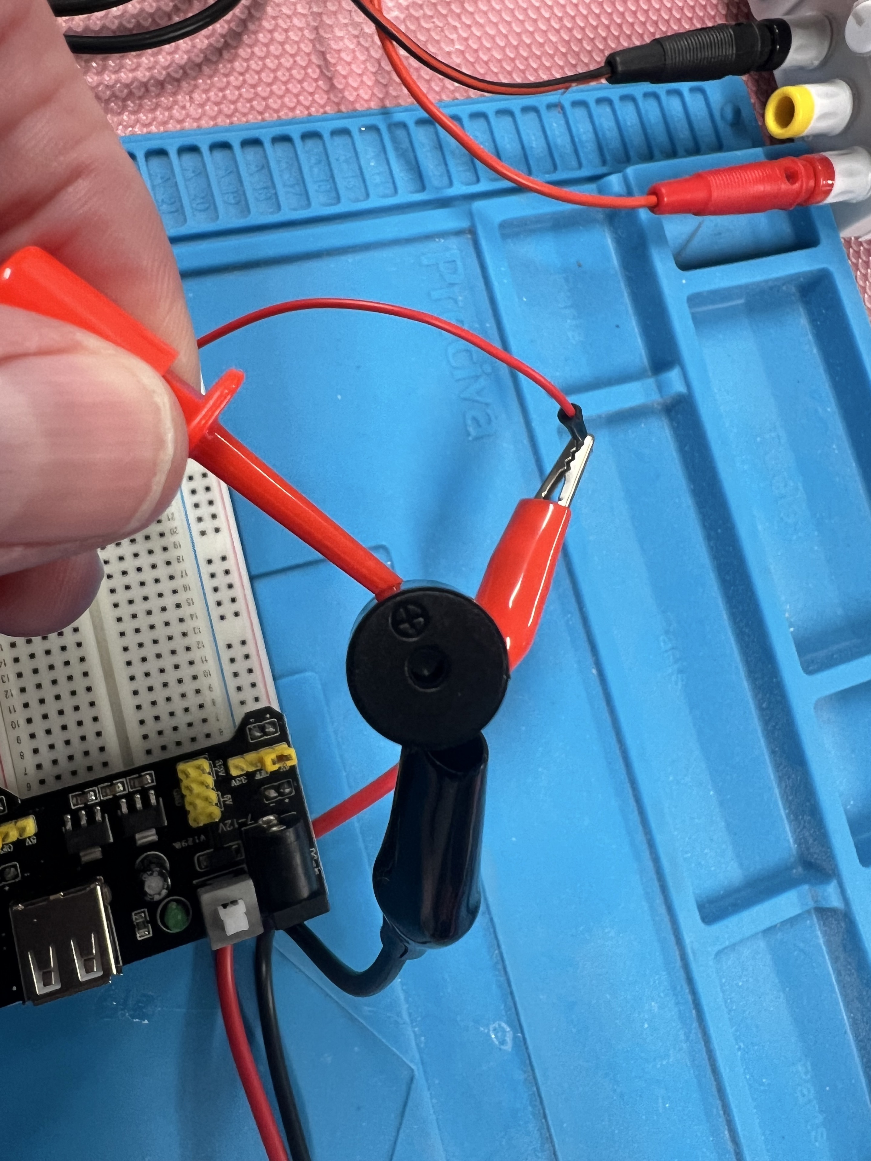 Alligator clips connecting a buzzer for the signal generator test